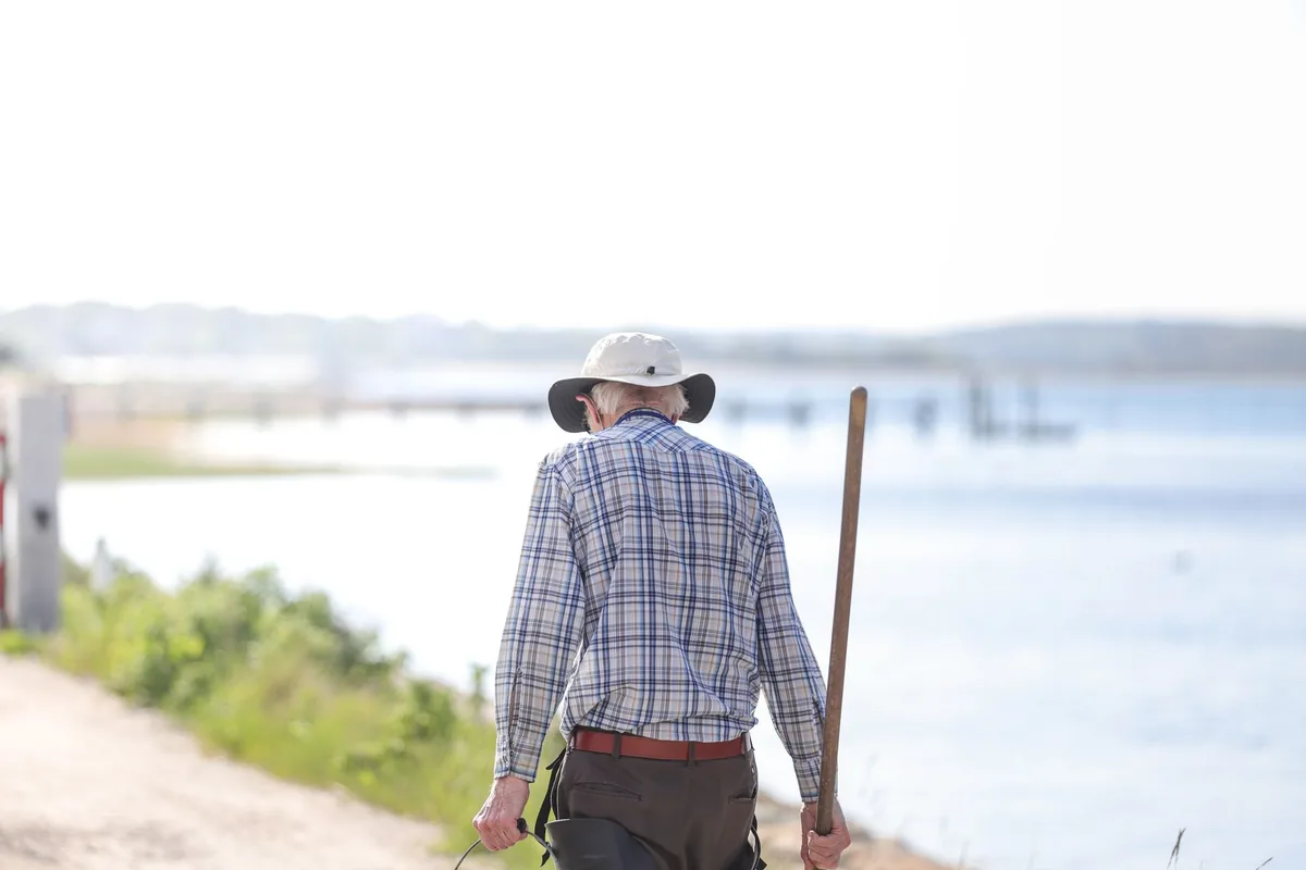 Homem idoso caminhando ao ar livre, cenário típico da claudicação por estenose do canal lombar